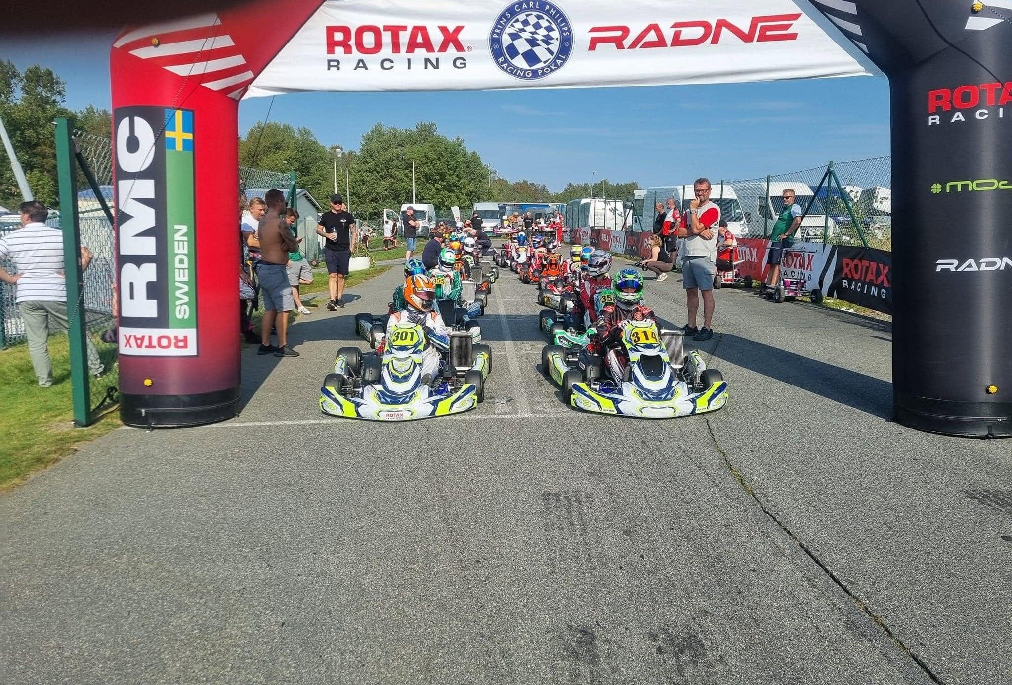 Synergy karts number 301 and 314 on the front row under an inflatable Rotax arch, more karts behind