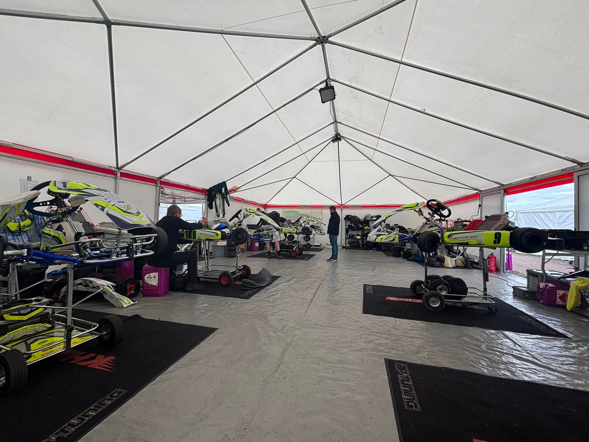 Mechanics working on Synergy karts in KH Racing’s awning at the 2026 Swedish Championship
